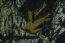 Load image into Gallery viewer, This ultra soft, medium weight printed fleece is the go to fabric for warmth.  The camouflage design features realistic branches and leaves in the colors of green, gray and brown on a black background.  It is perfect for creating jackets, vests, scarves, gloves, throws, bedding and more! 
