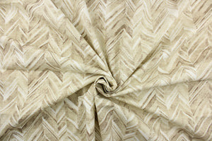  This fabric features a chevron design in shades of brown, beige, taupe, and white . 