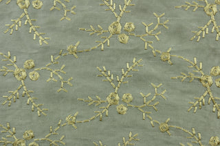  Twilight Snowfall features an embroidered floral vine in gold set against a gray background.  The embroidered design adds an elegant look to the fabric.  Uses include apparel, decorative pillows, window treatments and bedding.