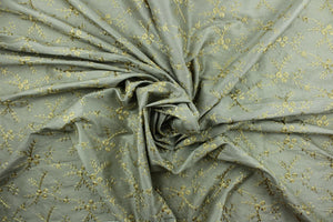  Twilight Snowfall features an embroidered floral vine in gold set against a gray background.  The embroidered design adds an elegant look to the fabric.  Uses include apparel, decorative pillows, window treatments and bedding.