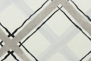 This fabric features a diagonal plaid design in black and gray against a white background .