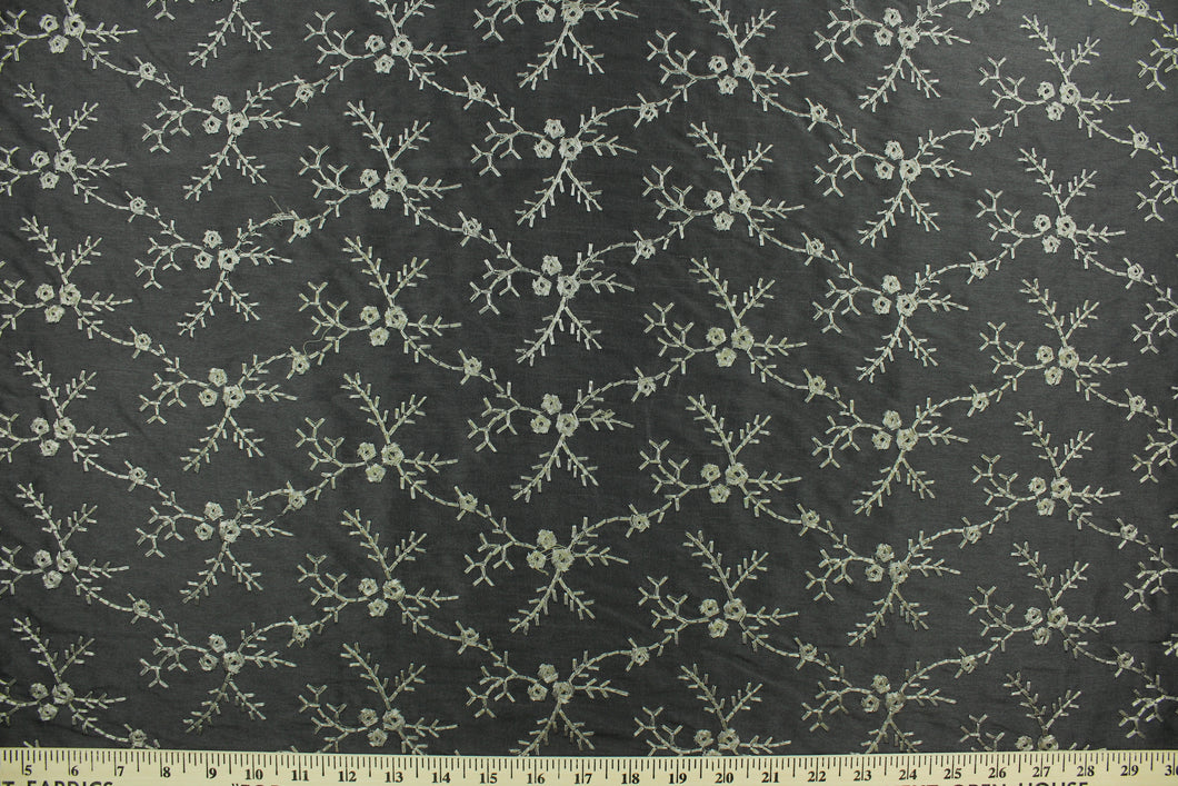 Midnight Snowfall features an embroidered floral vine in pewter set against a black background.  The embroidered design adds an elegant look to the fabric.  Uses include apparel, decorative pillows, window treatments and bedding.