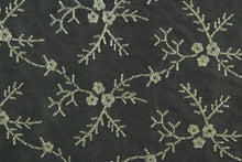 Load image into Gallery viewer, Midnight Snowfall features an embroidered floral vine in pewter set against a black background.  The embroidered design adds an elegant look to the fabric.  Uses include apparel, decorative pillows, window treatments and bedding.
