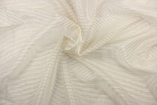 This sheer fabric features a stripe design in a tan, white, beige, and black.