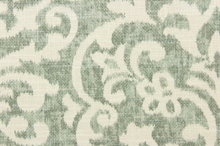 This fabric features a demask design in a washout green tone against a dull white background. 