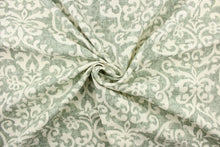 Load image into Gallery viewer, This fabric features a demask design in a washout green tone against a dull white background. 
