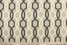 Load image into Gallery viewer, This outdoor fabric features a geometric design in black and a dull white against a taupe background . 
