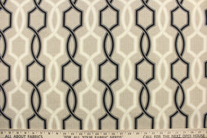 This outdoor fabric features a geometric design in black and a dull white against a taupe background . 