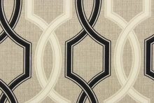 Load image into Gallery viewer, This outdoor fabric features a geometric design in black and a dull white against a taupe background . 
