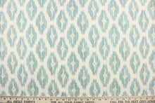 Load image into Gallery viewer, This geometric medium scale ikat design in gray blue with a tan dot in the center against a off white .

