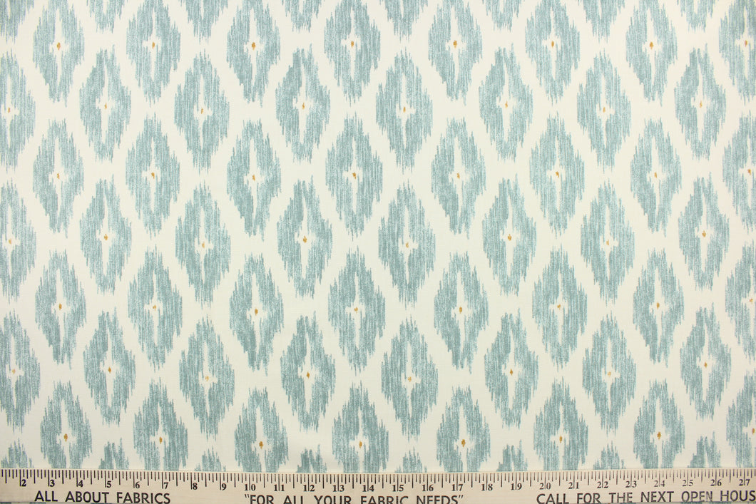 This geometric medium scale ikat design in gray blue with a tan dot in the center against a off white .