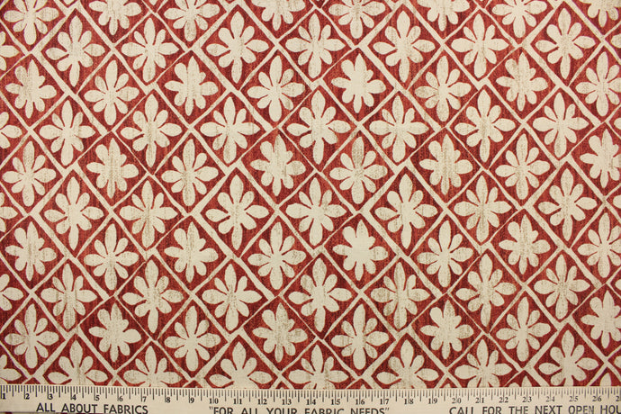This fabric features a floral design in beige and tan against a cayenne red with a slight distress look .