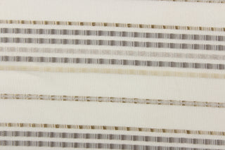  This sheer fabric features a stripe design in silver, cream, gray, and gold against a off white backgrounds. 