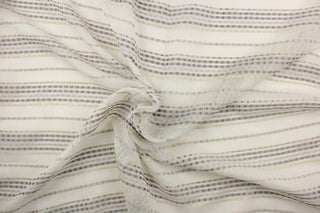  This sheer fabric features a stripe design in silver, cream, gray, and gold against a off white backgrounds. 