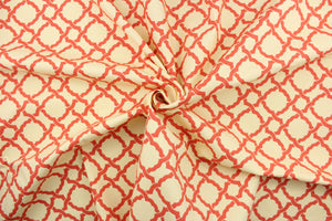 This fabric features a geometric design in a coral or light orange against a cream background.