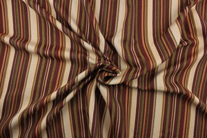This rich woven yarn dyed fabric features bold multi width striped pattern in burgundy, green, gold, bronze, and beige. 