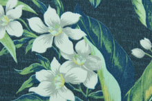 Load image into Gallery viewer, Tahiti features a tropical floral design in gray, white and green set against a navy blue background. It is perfect for any project where the fabric will be exposed to the weather.  Able to resist stains and water, and has a rating of 10,000 double rubs, UV tested and can withstand 500 hours of direct sunlight  Uses include cushions, tablecloths, upholstery projects, decorative pillows and craft projects. This fabric has a slightly stiff feel but is easy to work with.
