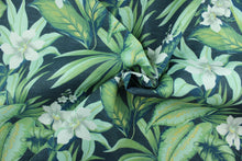 Load image into Gallery viewer, Tahiti features a tropical floral design in gray, white and green set against a navy blue background. It is perfect for any project where the fabric will be exposed to the weather.  Able to resist stains and water, and has a rating of 10,000 double rubs, UV tested and can withstand 500 hours of direct sunlight  Uses include cushions, tablecloths, upholstery projects, decorative pillows and craft projects. This fabric has a slightly stiff feel but is easy to work with.
