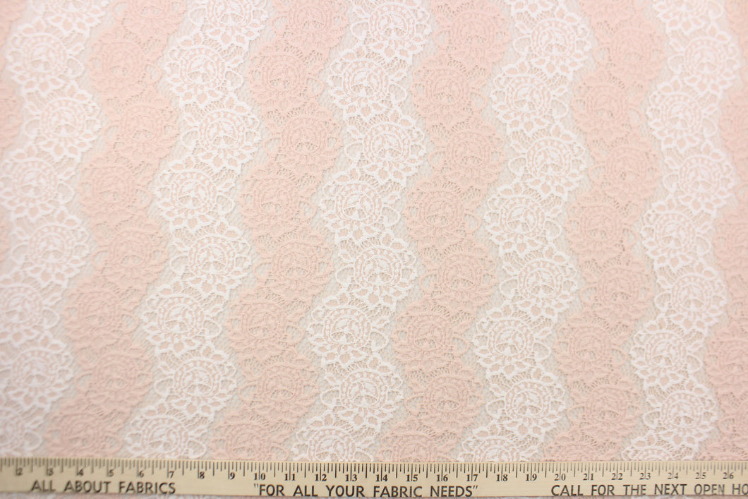 This lace features a floral design in a pale pink and white with a stretch.