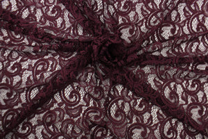 This lace features a floral design with glitter in a plum purple with a stretch. 