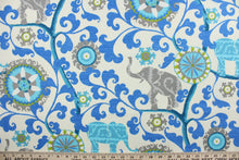 Load image into Gallery viewer, Menagerie is an outdoor fabric featuring suzani medallions and elephants in shades of blue, lime green and gray against a cream background.
