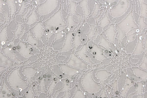 This lace features a floral sequin design in a silver or gray with a stretch. 