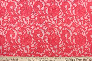 This lace features a floral design in a  hot coral pink with a stretch. 