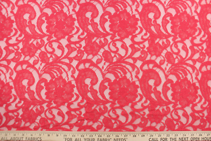 This lace features a floral design in a  hot coral pink with a stretch. 