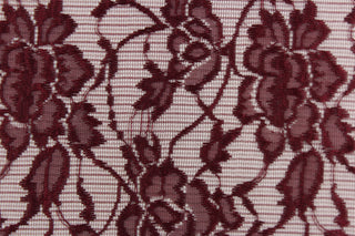  This lace features a floral design in a burgundy with a stretch.