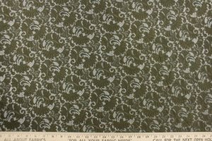 This lace features a ornamental design in a rich army green with a stretch. 