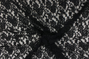 This lace features a floral design in black with a stretch. 