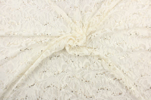 This lace features a floral sequin design in a white with a stretch.