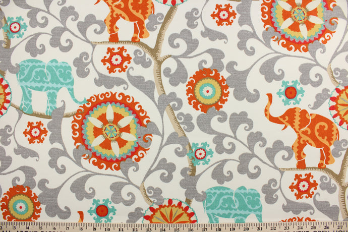 Menagerie is an outdoor fabric featuring suzani medallions and elephants in aqua, gold, gray, orange, red and tan against a cream background.