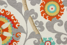 Load image into Gallery viewer, Menagerie is an outdoor fabric featuring suzani medallions and elephants in aqua, gold, gray, orange, red and tan against a cream background.
