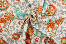 Load image into Gallery viewer, Menagerie is an outdoor fabric featuring suzani medallions and elephants in aqua, gold, gray, orange, red and tan against a cream background.
