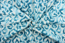 Load image into Gallery viewer,  Sariya features a slubby basket print with washed ikat design in turquoise against a white background with a stain resistant finish.  It can be used for several different statement projects including window accents (drapery, curtains and swags), decorative pillows, hand bags, bed skirts, duvet covers, upholstery and craft projects.  It has a soft workable feel yet is stable and durable with 20,000 double rubs.

