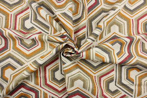  This fabric features a contemporary geometric design in taupe, beige, gray, orange, red, and off white. 