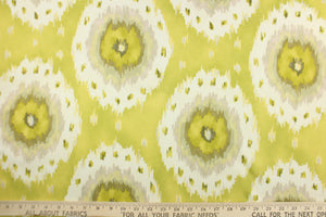 This fabric features a Ikat design in lime green, yellow, olive green, dull white, silver, pale khaki, and pale green. 
