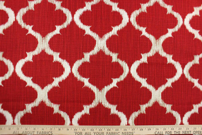 This fabric features a geometric design in rich red, white, and taupe .