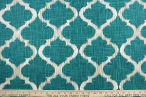  This fabric features a geometric design in teal, white, and taupe .