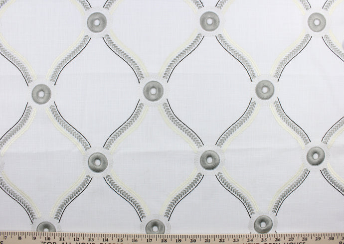  Estate is a multi purpose fabric featuring a traditional ogee design embroidered in gunmetal and eggshell with metallic highlights against a white background.  Uses include drapery, pillows, light upholstery, table runners, bedding, headboards, home décor and apparel.  