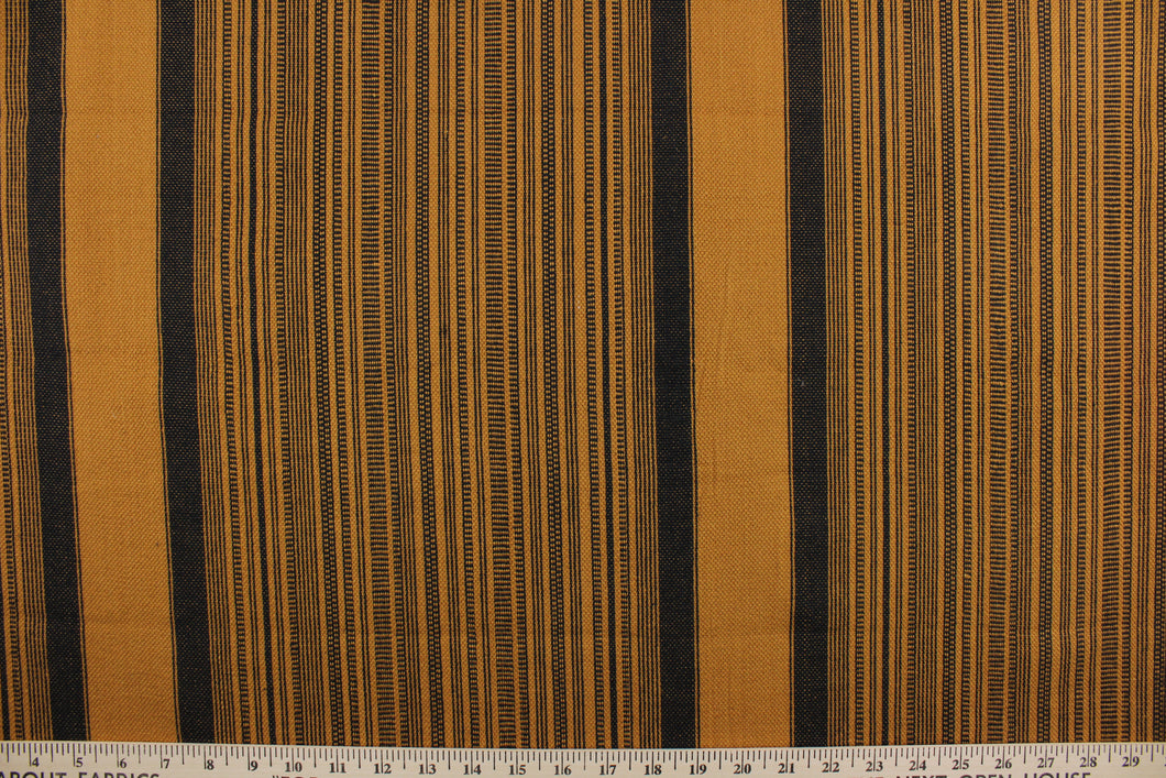 This multi purpose woven fabric features a multi width stripe design in golden brown and black.  It offers beautiful design, style and color to any space in your home.  It has a slightly stiff feel but is workable and durable.  Perfect for window treatments (draperies, valances, curtains, and swags), upholstery, cornice boards, accent pillows and home décor.