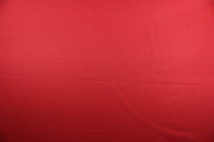 This beautiful solid red fabric has a smooth and lustrous appearance.  The  fabric offers a crisp hand and a stiff but flexible drape.  The glossy finish makes it great for apparel, drapery lining and much more.   