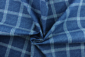 This solarium outdoor print features a plaid design with white and blue green stripes against a denim blue background.  It is durable and can withstand up to 500 hours of sunlight, water and stain resistant and has 10,000 double rubs.  It is perfect for cushions, tablecloths, decorative pillows and upholstery projects.  Bring indoors when not in use.  We offer this fabric in other colors.