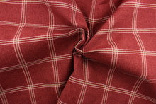 Load image into Gallery viewer, This solarium outdoor print features a plaid design with white and khaki stripes against a berry background.  It is durable and can withstand up to 500 hours of sunlight, water and stain resistant and has 10,000 double rubs.  It is perfect for cushions, tablecloths, decorative pillows and upholstery projects.  Bring indoors when not in use.
