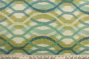 This fabric features a geometric design blue, turquoise, teal, lime green and seafoam against a natural background.