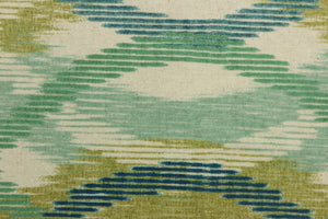 This fabric features a geometric design blue, turquoise, teal, lime green and seafoam against a natural background.