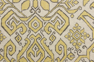This fabric features an Aztec design in  yellow with gray outline against a natural background. 