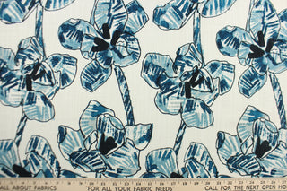 This fabric features a floral design in  varying shades of blue, black and hints of gray against a dull white background.