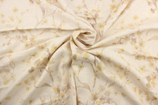 This fabric features a floral design in a light yellow, beige, hints of a green and taupe against a off white background.